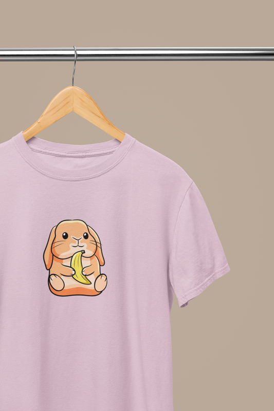 Heavyweight Unisex Crewneck T-shirt in light pink with a cute cartoon bunny holding a banana printed on the front of the t-shirt